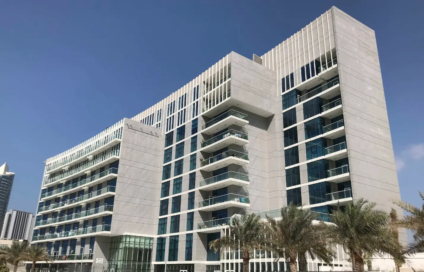 Detailed view of private glass balconies and exterior mid-rise structure at By The Sea Tower in Shams Abu Dhabi.