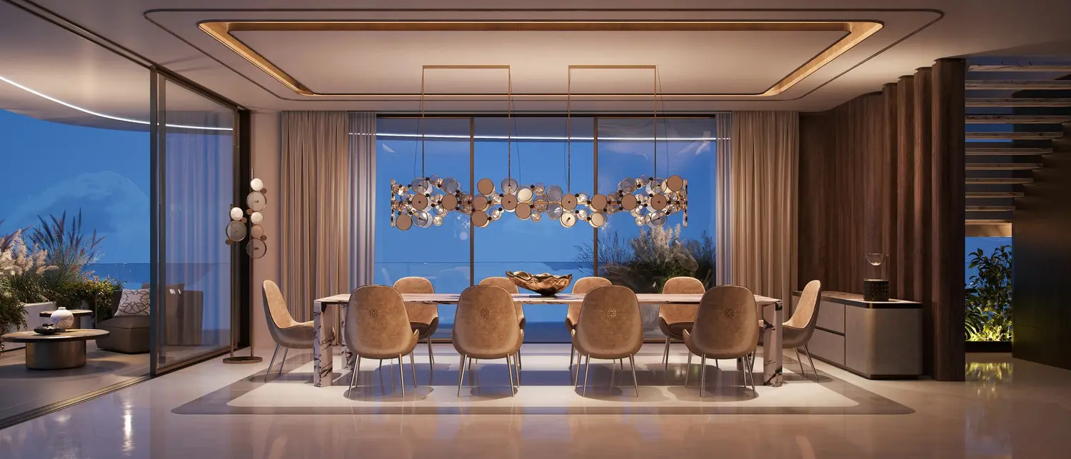 Elegant dining room space inside Elie Saab Waterfront Abu Dhabi apartments overlooking the sea through floor-to-ceiling windows.